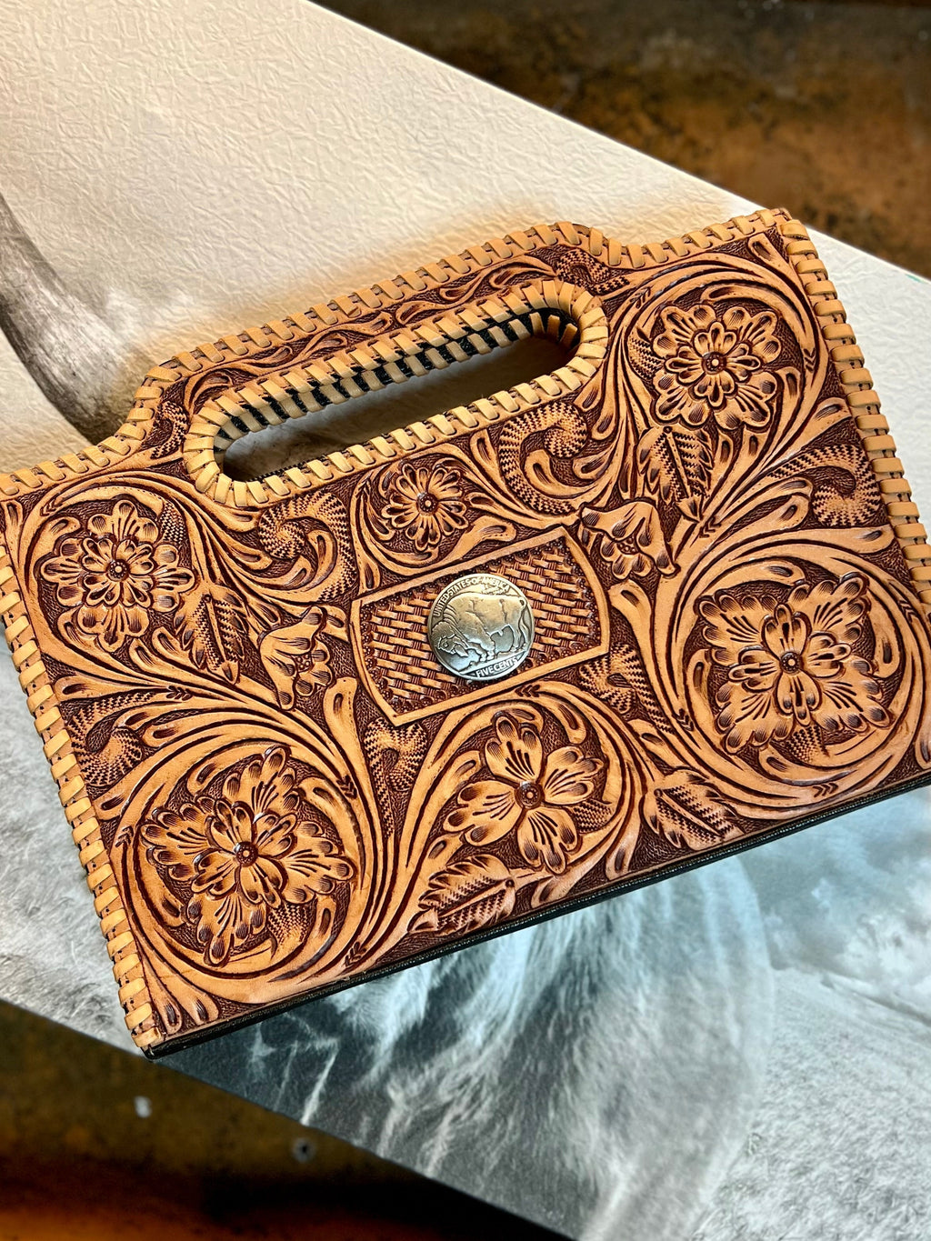 Tooled leather bag. Leather bag. Leather clutch. Leather shoulder bag. Tooled leather. Buffalo. Whipstitching. Western Style. Cowgirl bag. Cowgirl accessories. Western accessories. Western boutique. Cowgirl Boutique. Small business. Woman owned. 