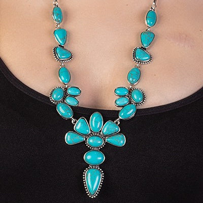 Introducing the For The Glory Necklace, a luxury accessory that brings together bold & intricate design elements. This statement piece features a delicate squash blossom drop, framed by an eye-catching chunky chain link chain of 28" in length. Choose from two colors: turquoise & silver or copper & ivory to best compliment your look. Step out in style and make a lasting impression.
