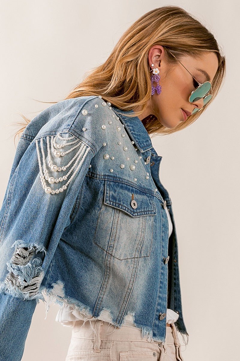 Introducing the Little Miss Priss Pearly Denim Jacket, a luxurious statement piece. Crafted from distressed denim, tastefully detailed with pearl beads, and cut in a fashionista-approved cropped silhouette, this jacket exudes modern elegance. Command attention with the Pearly Denim Jacket and be the envy of all stylish style setters.