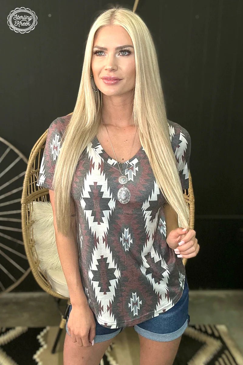 Explore endless style possibilities with the Aztec Kingdom Top! This unique top features a bold deep red, brown, and white aztec print that pairs perfectly with jeans, shorts, and skirts alike. A must-have for adding a splash of color and fun to your wardrobe! 