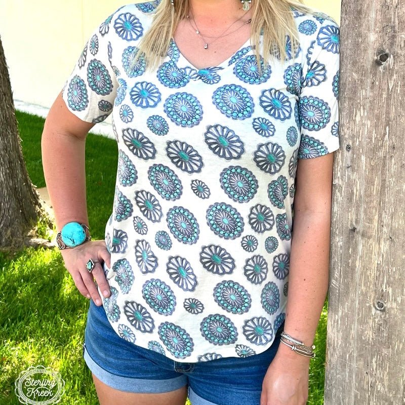 Take your style to the great, wild West with the PLUS Concho City Top! This stylish white vneck top is embellished with shiny conchos all over, giving your look a touch of cowgirl chic! Pop it on for an evening out or sunday brunch and turn heads everywhere you go! Yee-haw!  55% cotton 40% polyester 5% spandex   Measurements are with shirt laid flat   Meredith is wearing a Medium