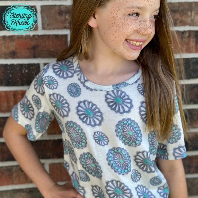 Brew up some cowboy vibes with Concho City Top Kids! This white top with concho designs is perfect for lending your little one a bit of western flair! Dress 'em up just right with this fun and fashionable kid's top! Yeehaw!  26% Cotton, 69% Polyester, 5% Spandex