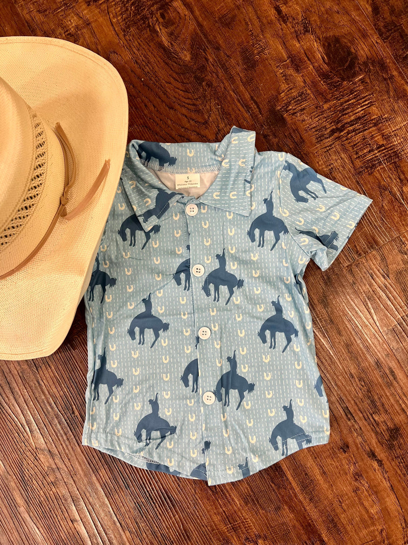 This Kids Lucky Cowboy Button Up is the perfect way to add a dash of western style to your little one's wardrobe! In a baby blue hue, this short-sleeved collared shirt will have them galloping around in style with its bucking-horse, horseshoe detailing. Yeehaw!  95% Cotton, 5% Spandex