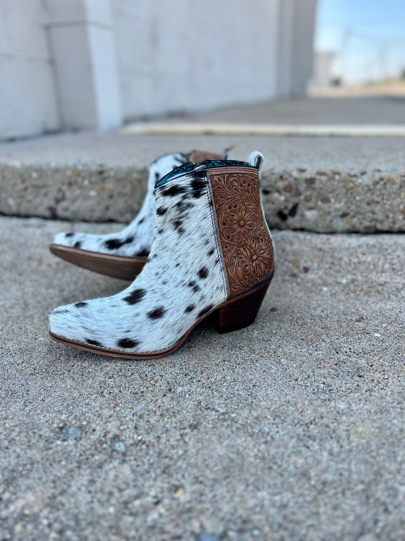 Step into luxury with the Laramie Plains Myra boots. Crafted with floral tooled leather on the ankle, the Myra offers an elegantly ornamented aesthetic. The interior zipper allows for easy on and off, while the hair on hide leather ensures quality and comfort. This ankle boot is the perfect choice for any special occasion.  2" Heel 