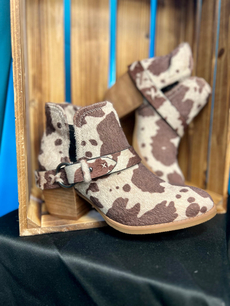 Step up your style game with the Moove Out The Pasture Booties! Featuring a bold cow print faux fur, 2 1/2" wood heel, 6" total height, plus inside and outside ankle slits and a wrap around ankle strap, these booties will take your look to the next level. Show ‘em you mean business!