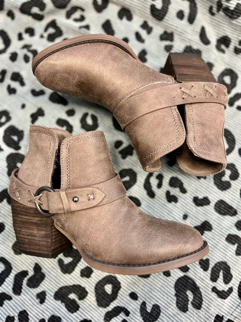 Step up your style game with The Barnyard Dance Booties ! Featuring a taupe color leather,  2 1/2" wood heel, 6" total height, plus inside and outside ankle slits and a  decorative wrap around ankle strap, these booties will take your look to the next level. Show ‘em you mean business!