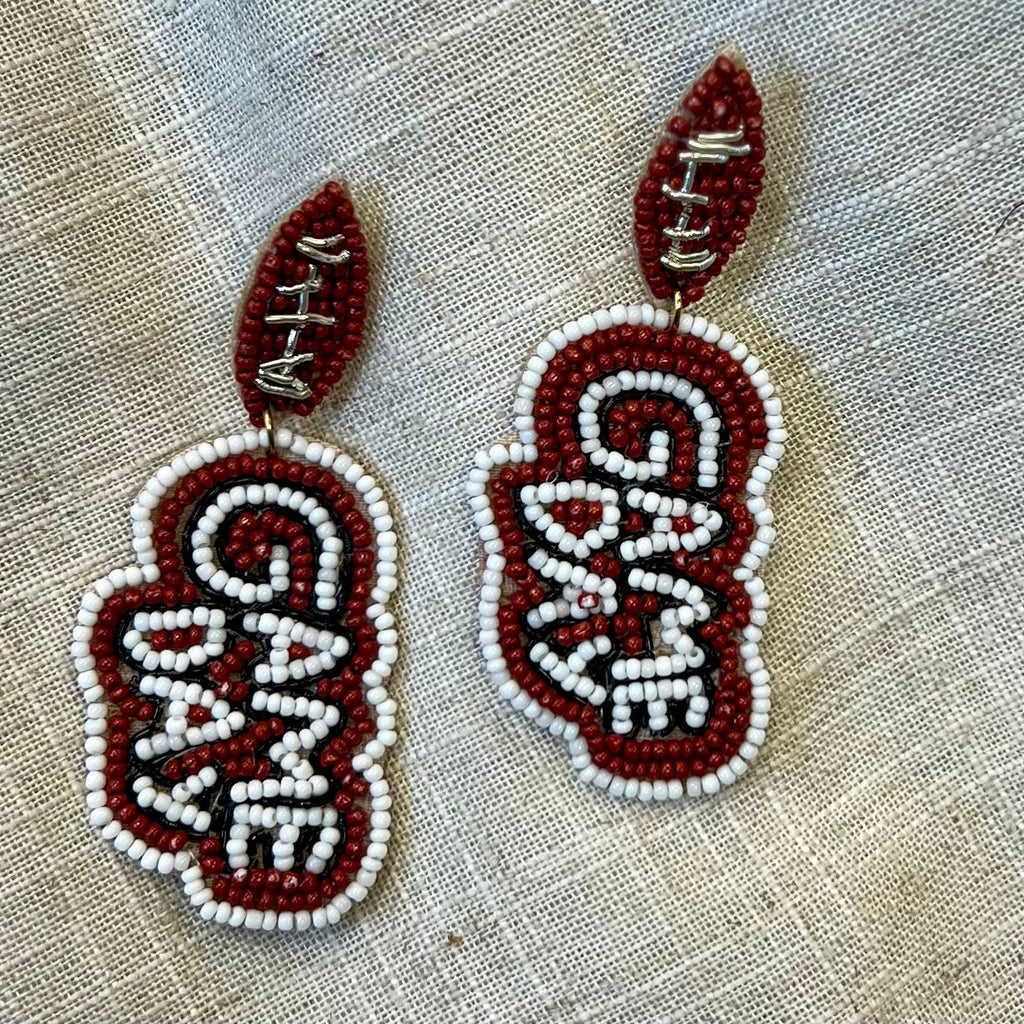 Score a touchdown at your next game day party with these fun and festive earrings! Featuring a football-shaped seed bead and a 3" dangle, these post-back earrings make a perfect sporty statement - wear them with pride and show your team spirit!