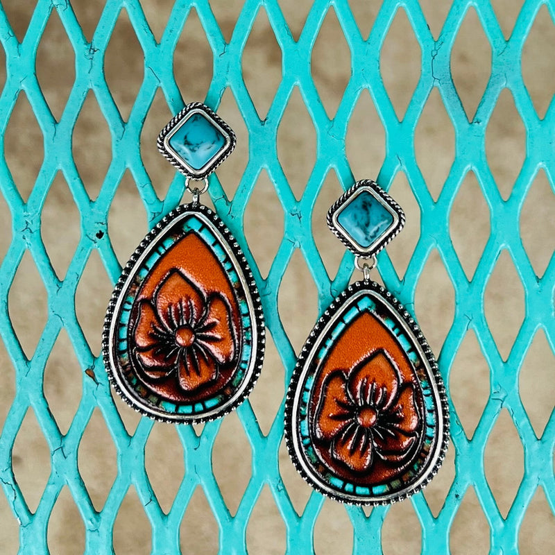 Indulge in these luxurious floral-stamped dangle earrings, crafted with soft brown leather, a gorgeous turquoise stone, turquoise accents, and finished with a high-shine silver plate. Perfect for lending a subtle elegance to your look, their 2-inch length adds an ideal finishing touch.