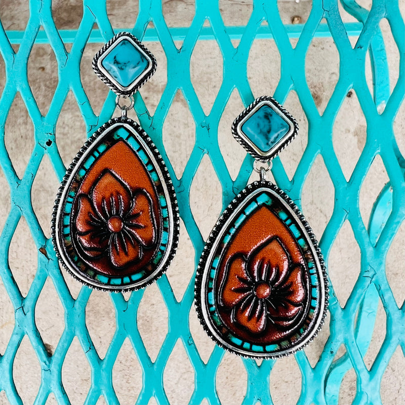 Indulge in these luxurious floral-stamped dangle earrings, crafted with soft brown leather, a gorgeous turquoise stone, turquoise accents, and finished with a high-shine silver plate. Perfect for lending a subtle elegance to your look, their 2-inch length adds an ideal finishing touch.