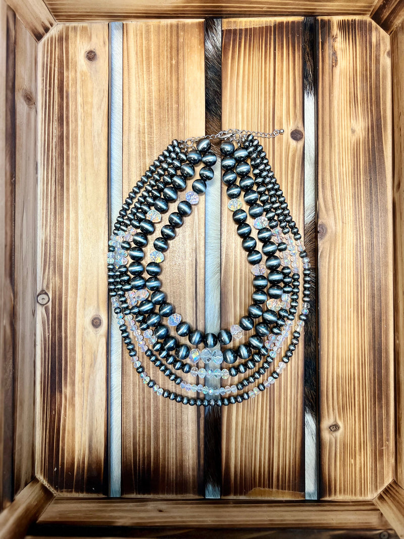 Our "It's Crystal Clear" Necklace has a western style that's guaranteed to make a statement. With Navajo pear beads and glass crystal beads mixed, in lengths of 16"-18" with a 3" extender, all that's left to do is shine! It's crystal clear what a showstopper this necklace will be!