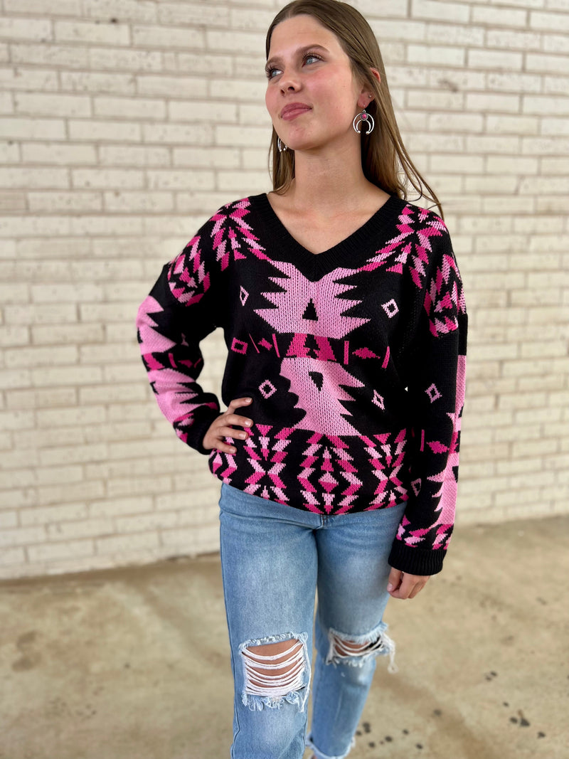 Stay warm in style with the Temple of Rosa Sweater! It's a cozy black sweater featuring an eye-catching hot pink Aztec pattern, perfect for adding a pop of color to any look. Crafted from 100% acrylic and featuring a v-neckline, long sleeves, and an oversized fit, this sweater is sure to become your next favorite. Get your temple on!
