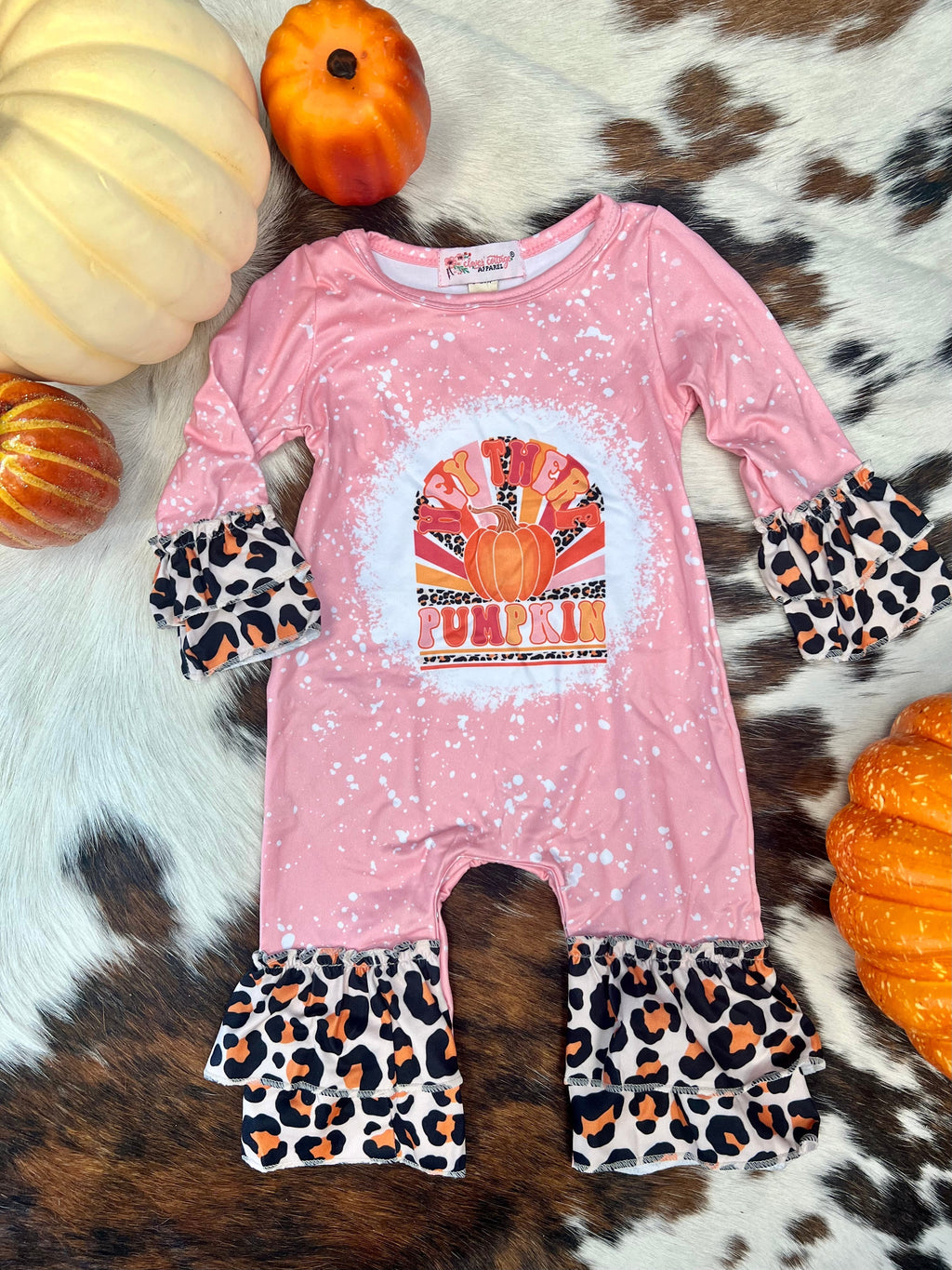 Welcome the fall season in style with our Hey There Pumpkin Romper! This playful one-piece features a fun leopard print trim, a unique pink acid spatter look, a scoop neckline, and a button snap leg closure. Enjoy the butter soft material that'll keep you feeling comfy and looking cute all day long. Perfect for dancing through the changing leaves in October!