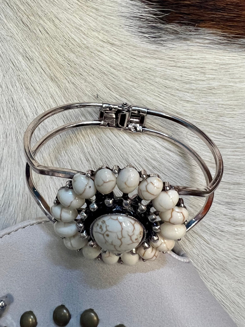Our Ivory Bracelet will have you looking stylishly wild. With its Western-inspired design and a round stone pendant accentuated ivory stones, this cuff bracelet will add a fierce touch to your wardrobe. Not to mention, its charm size of 2", and diameter of approx 3" will fit you perfectly. Get ready to hit the town in the ultimate fashion statement—nickle free!