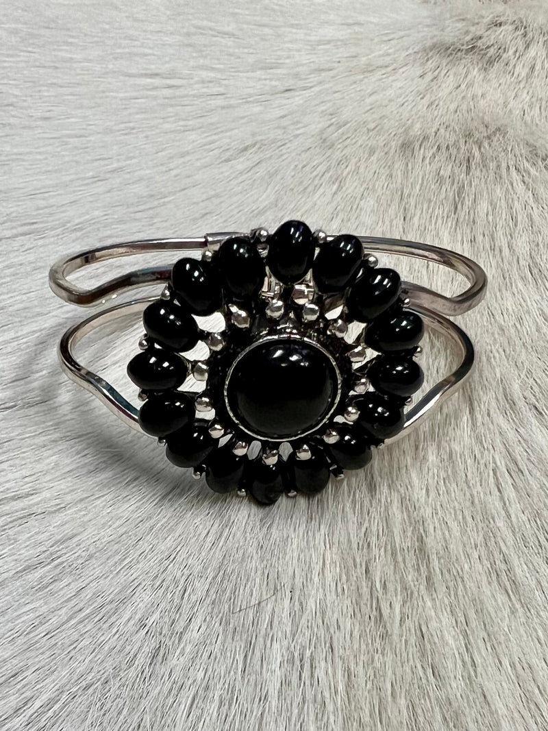 Our Black Stones Bracelet will have you looking stylishly wild. With its Western-inspired design and a round stone pendant accentuated with black stones, this cuff bracelet will add a fierce touch to your wardrobe. Not to mention, its charm size of 2", and diameter of approx 3" will fit you perfectly. Get ready to hit the town in the ultimate fashion statement—nickle free!