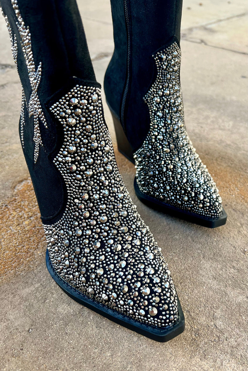 Add Glamour to any party with these "Lux" Black Rhinestone Booties with front rhinestone detailing and side flared out feathered detailing. These booties have a Pointed Toe Silhouette,  side zipper closure, 3" wooden block heel, 7" calf length from ankle to top of bootie. 10" total inches tall from sole to top of Bootie.  These booties are made of a soft suede like material. 