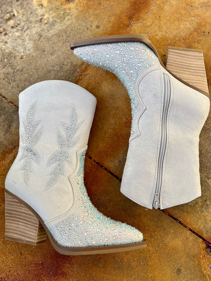 Add Glamour to any party with these "Lux" Grey Rhinestone Booties with front iridescent rhinestone detailing and side flared out feathered detailing. These booties have a Pointed Toe Silhouette,  side zipper closure, 3" wooden block heel, 7" calf length from ankle to top of bootie. 10" total inches tall from sole to top of Bootie.  These booties are made of a soft suede like material. 