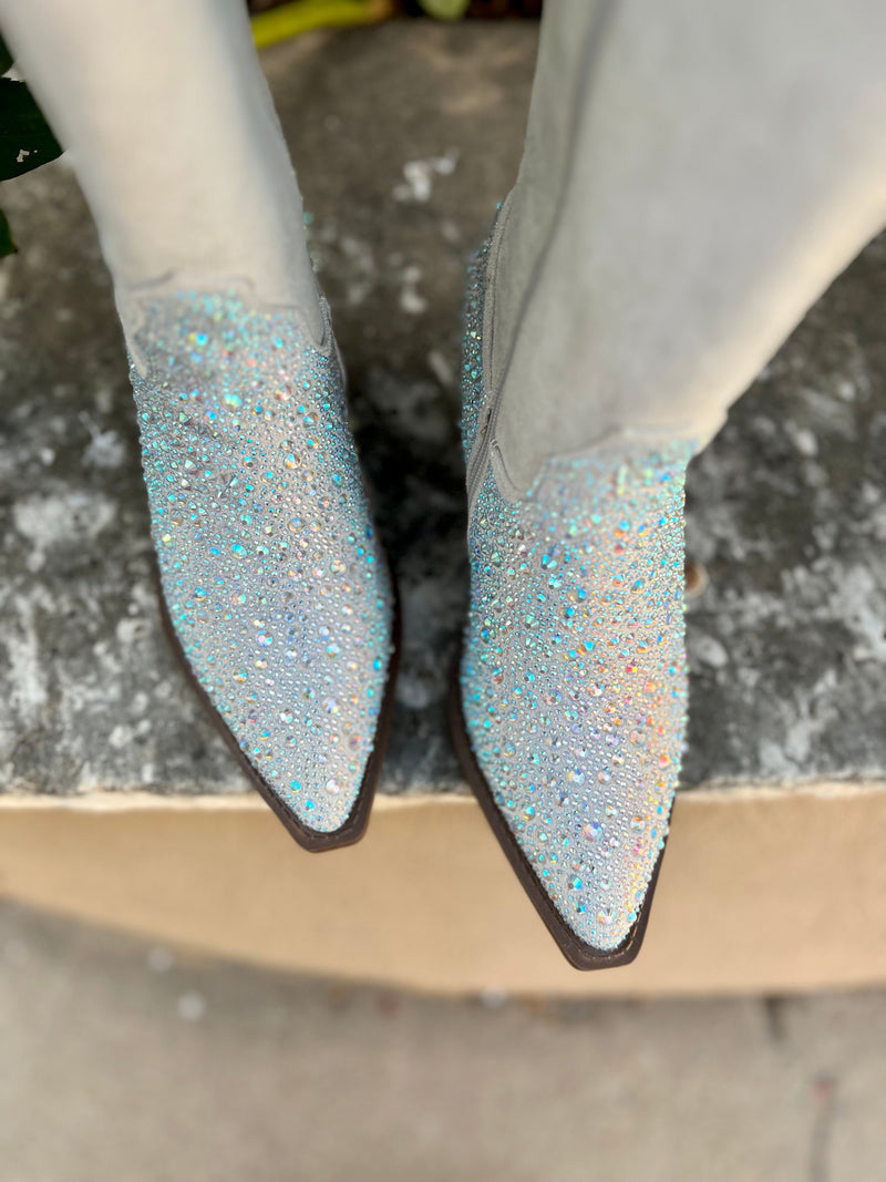 Add Glamour to any party with these "Addie" Grey Rhinestone Booties with front iridescent rhinestone detailing and side flared out feathered detailing. These booties have a Pointed Toe Silhouette,  side zipper closure, 3" wooden block heel, 14" calf length from ankle to top of bootie. 17" total inches tall from sole to top of Bootie.  These booties are made of a soft suede like material. 