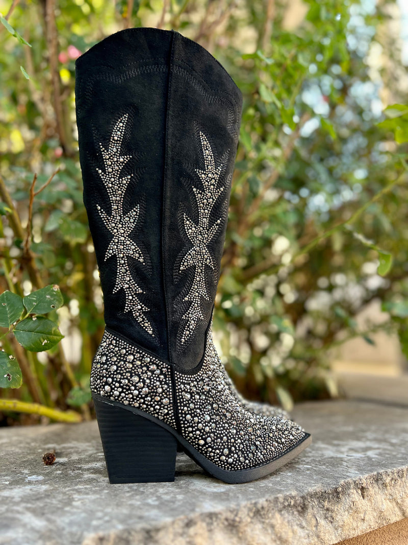 Add Glamour to any party with these "Addie" Black Rhinestone Boots with ankle silver rhinestone detailing and side flared out feathered detailing. These boots have a Pointed Toe Silhouette,  side zipper closure, 3" wooden block heel, 14" calf length from ankle to top of bootie. 17" total inches tall from sole to top of Bootie.  These boots are made of a soft suede like material. 