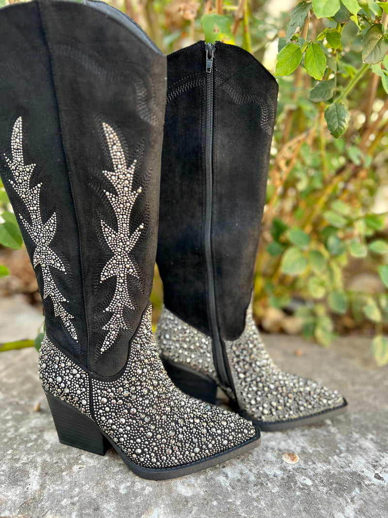 Add Glamour to any party with these "Addie" Black Rhinestone Boots with ankle silver rhinestone detailing and side flared out feathered detailing. These boots have a Pointed Toe Silhouette,  side zipper closure, 3" wooden block heel, 14" calf length from ankle to top of bootie. 17" total inches tall from sole to top of Bootie.  These boots are made of a soft suede like material. 