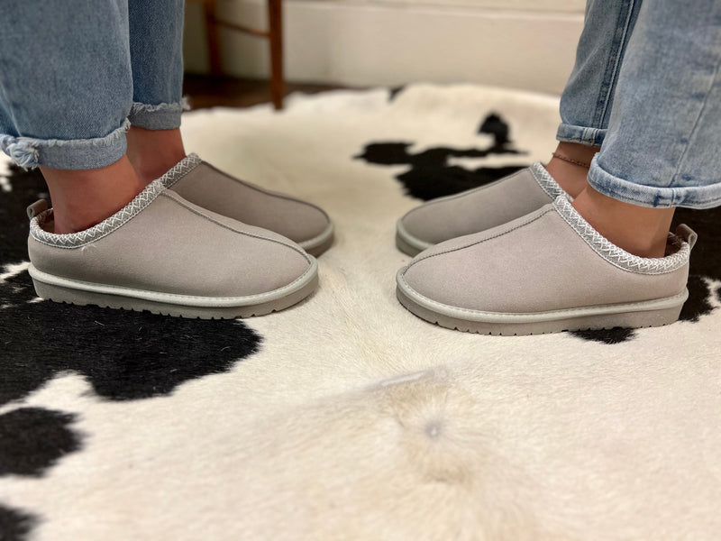 Snuggle into these UGGHH I Need These Slippers! The fur lined interior and ugg style design makes them a must-have, cozy-comfy addition to any lazy day. The grey hue and hard sole make them practical and sturdy, while the super comfort level makes them a treat for your feet.