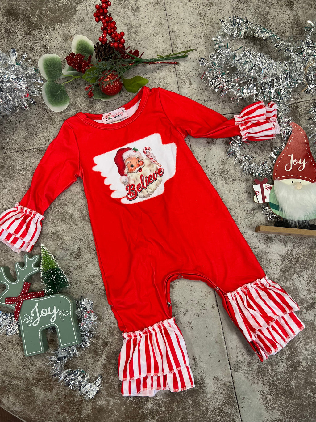 Your lil’ one will look as cute as Santa’s list in this KIDS Peppermint Believe Jumper. Crafted from butter-soft 95% cotton and 5% spandex, this red romper features a white and red striped ruffled hem and a snap bottom closure for easy changing. Plus, the festive Santa Claus “Believe” graphic is sure to get their spirits soaring!