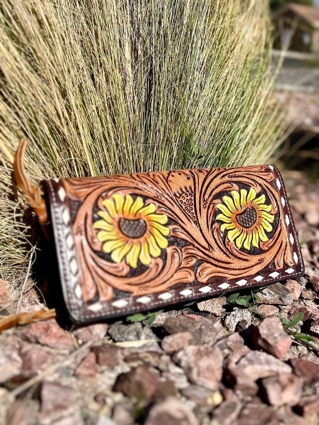 Introducing the Big Ole' Sunflower Wallet--the perfect companion for going out on the town! With an eye-catching floral tooling and a white whip stitch, you'll be stoppin' traffic all night. Brown leather and ready for a wristlet, crossbody, or wallet, this 4"X8" beauty has multiple credit card slots and compartments to keep your stuff safe and secure. So go ahead--make a style statement!