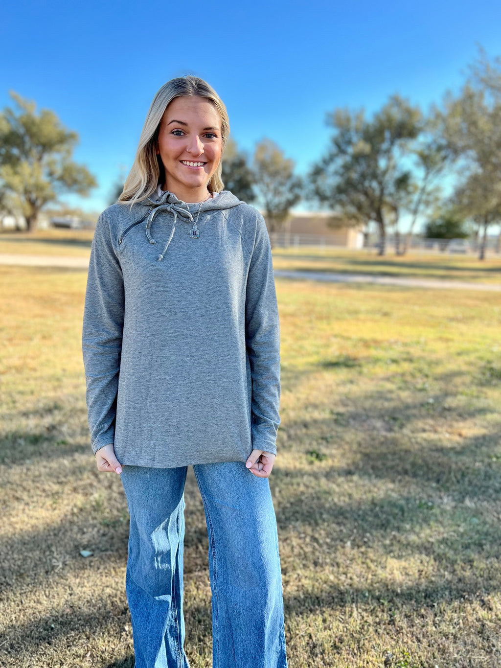 Take your style to new heights with this On Cloud 9 Pullover! It's grey striped, hooded and raglan, and features a unique zipper detail for a modern look. Knit from a cozy blend of Polyester, Rayon and Spandex, you'll stay comfy and look cool in this long sleeve top. Soar to the top of the fashion world!