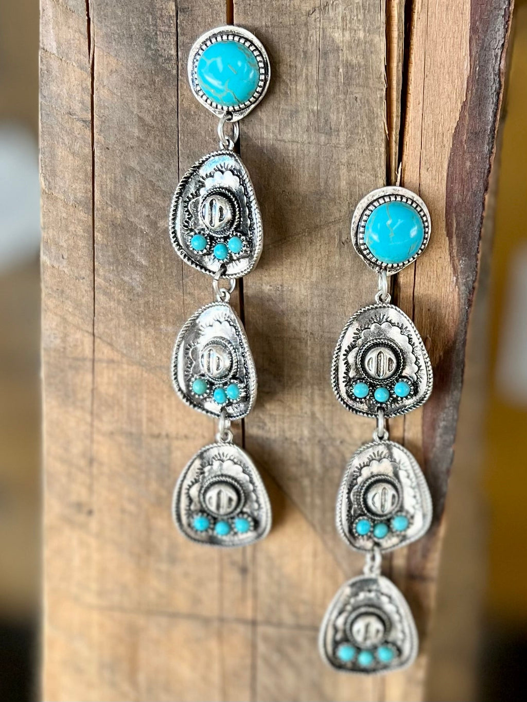 Add some Western flair to any outfit with these stylish Life to Hang Your Hat On Earrings! Not only are they the perfect way to add a pop of daring color to your look, but they also feature a cool cowboy hat shape fashioned out of silver and tastefully adorned with turquoise stones. Show the wild, wild west who's boss with these 4" dangle earrings, secured with the classic fish hook closure. Yeehaw!