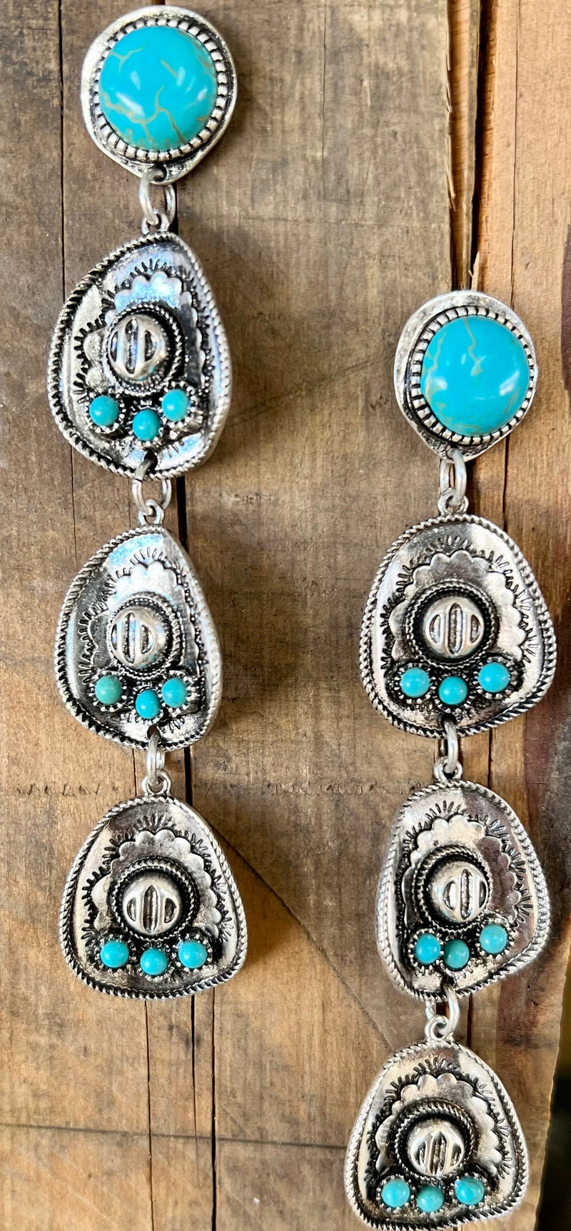 Add some Western flair to any outfit with these stylish Life to Hang Your Hat On Earrings! Not only are they the perfect way to add a pop of daring color to your look, but they also feature a cool cowboy hat shape fashioned out of silver and tastefully adorned with turquoise stones. Show the wild, wild west who's boss with these 4" dangle earrings, secured with the classic fish hook closure. Yeehaw!