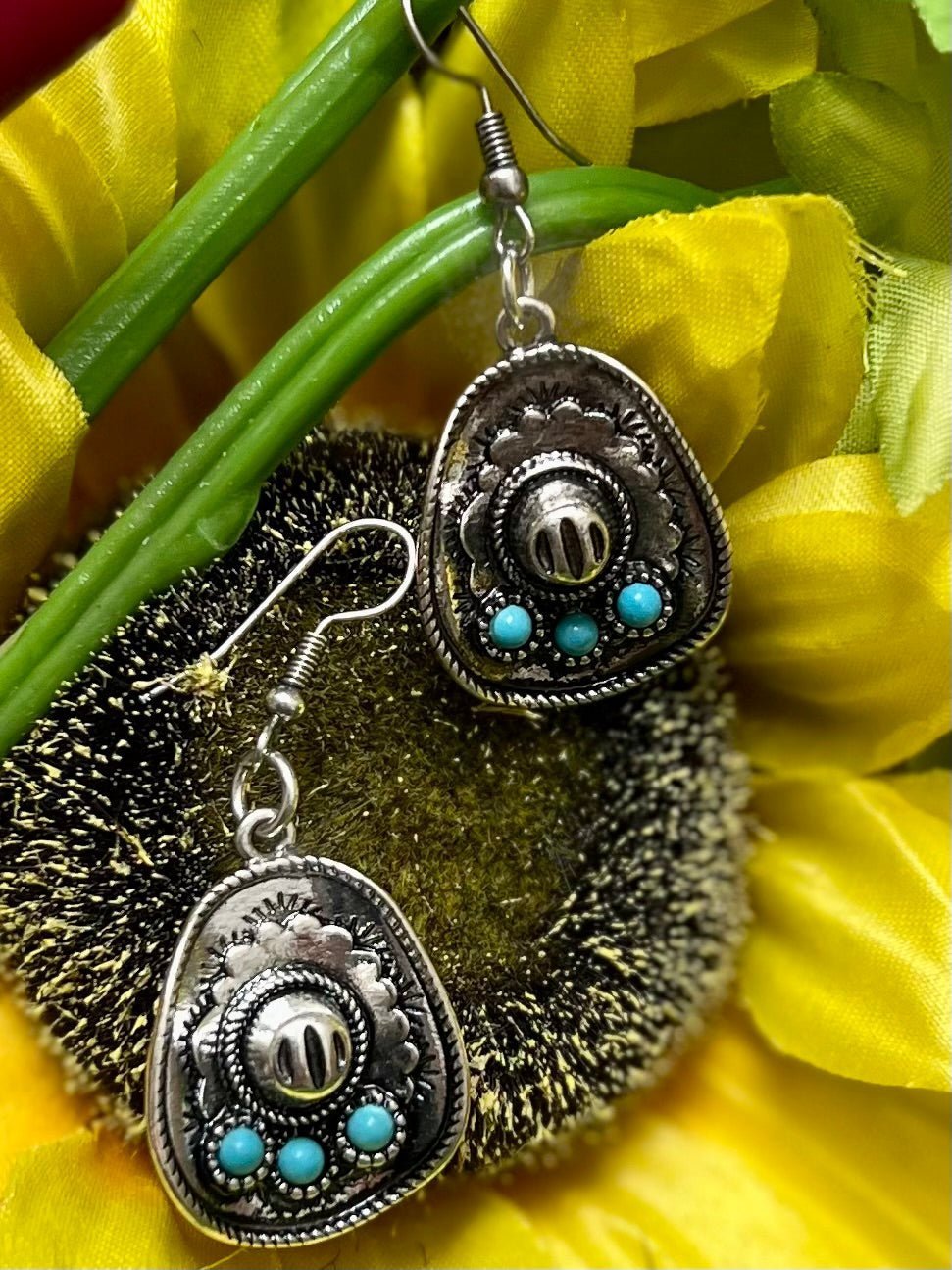 Add some Western flair to any outfit with these stylish Life to Hang Your Hat On Earrings! Not only are they the perfect way to add a pop of daring color to your look, but they also feature a cool cowboy hat shape fashioned out of silver and tastefully adorned with turquoise stones. Show the wild, wild west who's boss with these 1 3/4" dangle earrings, secured with the classic fish hook closure. Yeehaw!