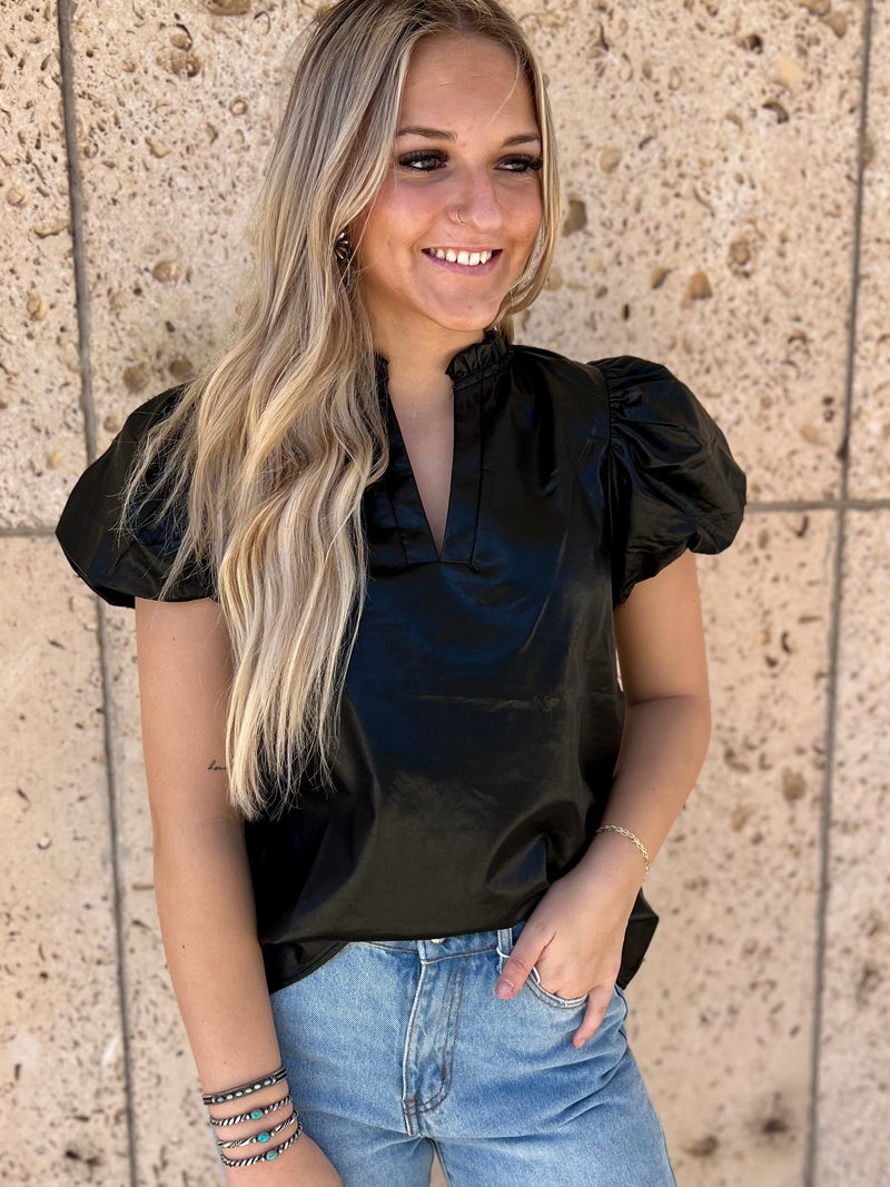 Capture that edgy downtown look with the Metro Night Out Top! This faux leather piece gives you an unbeatable rocker-chic vibe with its v neckline, ruffled puffed sleeves, and short sleeve cut. Get ready to turn some heads with this sleek black number!