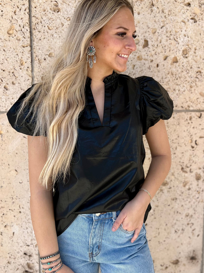 Capture that edgy downtown look with the Metro Night Out Top! This faux leather piece gives you an unbeatable rocker-chic vibe with its v neckline, ruffled puffed sleeves, and short sleeve cut. Get ready to turn some heads with this sleek black number!