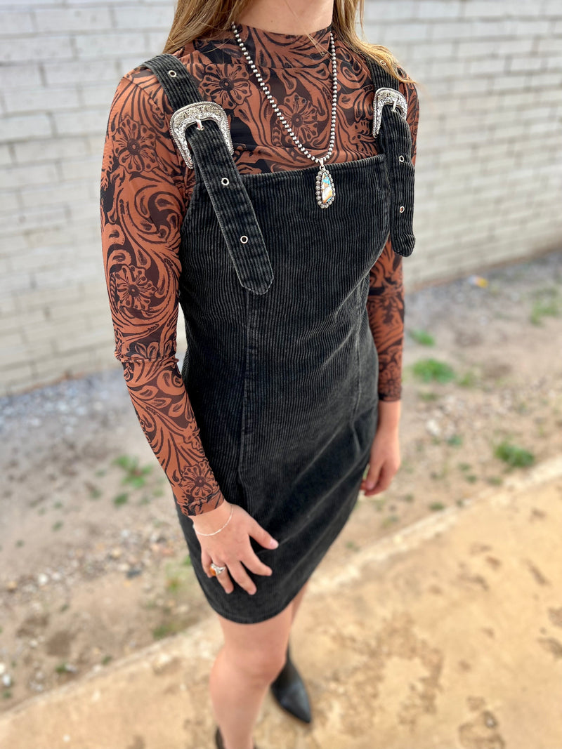 Yee-haw! Round up your wild-west style with the Ranch Rodeo Corduroy Dress. In ash black, this corduroy dress will make a bold statement that won't be forgotten. You'll love the thigh length, belt buckle straps, and fitted style. Zip up and ride off in fashion!