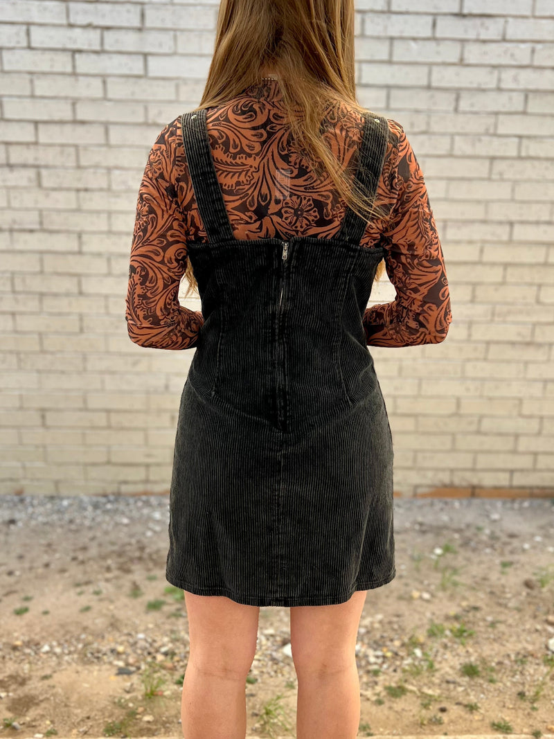 Yee-haw! Round up your wild-west style with the Ranch Rodeo Corduroy Dress. In ash black, this corduroy dress will make a bold statement that won't be forgotten. You'll love the thigh length, belt buckle straps, and fitted style. Zip up and ride off in fashion!