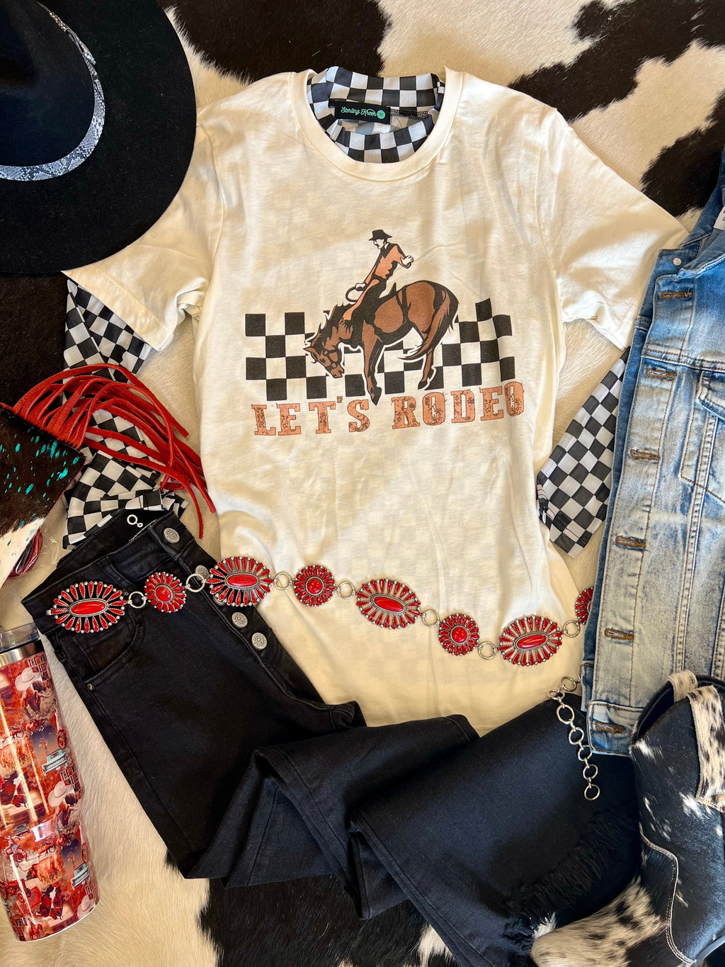 Saddle up in style with this Let's Rodeo tee! Made with 100% cotton, this cream-colored shirt features a checkered horse and cowboy graphic, perfect for any cowboy or cowgirl. Whether you're at a rodeo or just want to add some western flair to your wardrobe, this tee is sure to be a hit. Giddy up!