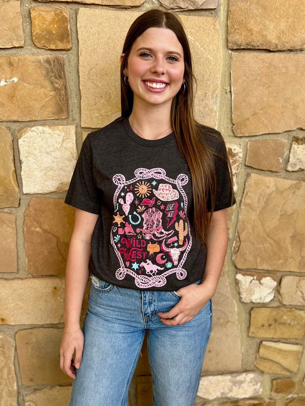 Saddle up and get ready to wrangle in style with our Colors of the Wild West Tee! This heather charcoal grey shirt features a crew neck, short sleeves, and a playful print of all the western essentials including a rope, cowboy hat, cactus, horse shoe, and barrel racer. Made from 100% cotton for ultimate comfort, pair it with your favorite cowboy boots for the perfect western-inspired look. Giddy up!