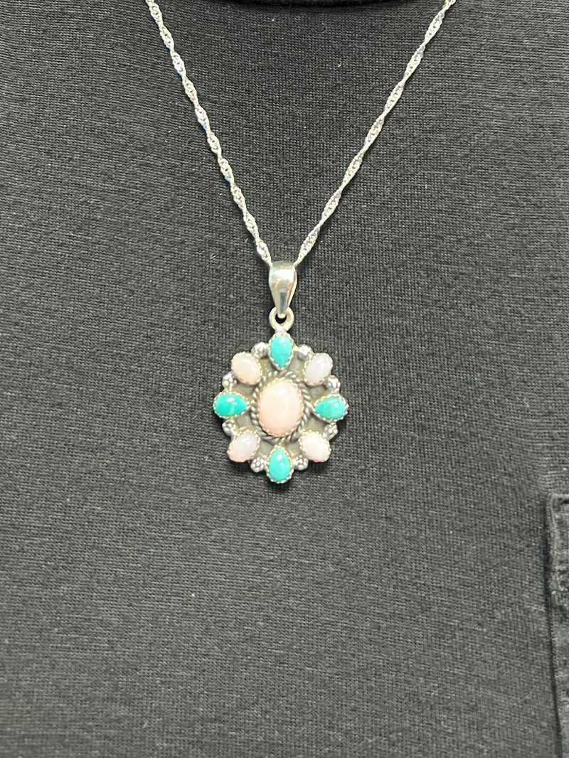 This unique piece of jewelry from the Hana Collection is a timeless piece crafted with luxurious details - made with sterling silver and a handcrafted Pink Opal and Turquoise pendant, this pendant is sure to exude sophistication and exclusivity. Perfect for any special occasion, this pendant is handmade by Navajo artisans from Gallup, New Mexico.  Pendant Measures: 1 "  Suggested retail value: $250.00