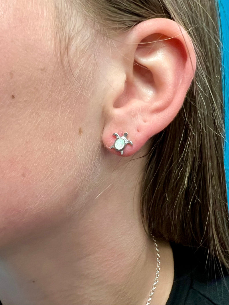 The Opal Turtle Earrings are Navajo Handcrafted Sterling Earrings feature genuine opal stone set in a adorable sterling Silver Turtle design. The perfect accessory for the stylish and sophisticated, these are a timeless addition to any wardrobe.  Suggested retail value:$59.99