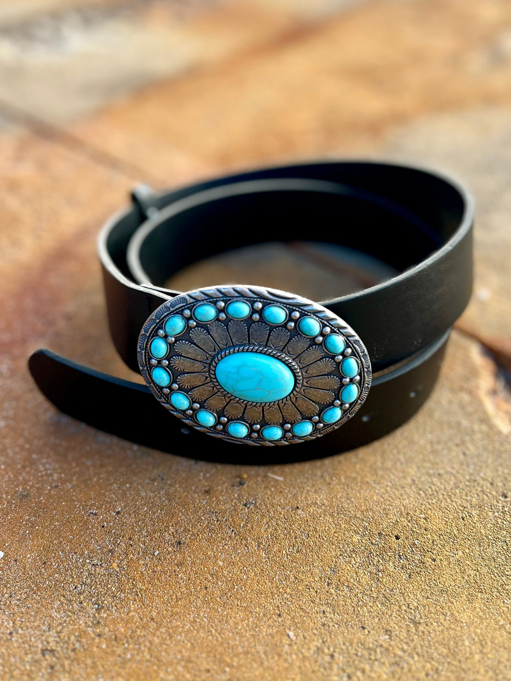 Be the King of the Ranch with The Center of His World Belt. Crafted from sleek black leather and adorned with a unique Silver & Turquoise Stone Concho Buckle, this 2" western belt will make you stand out in style. With a 41" length, it's the perfect fit for any cowboy. Yee-haw!