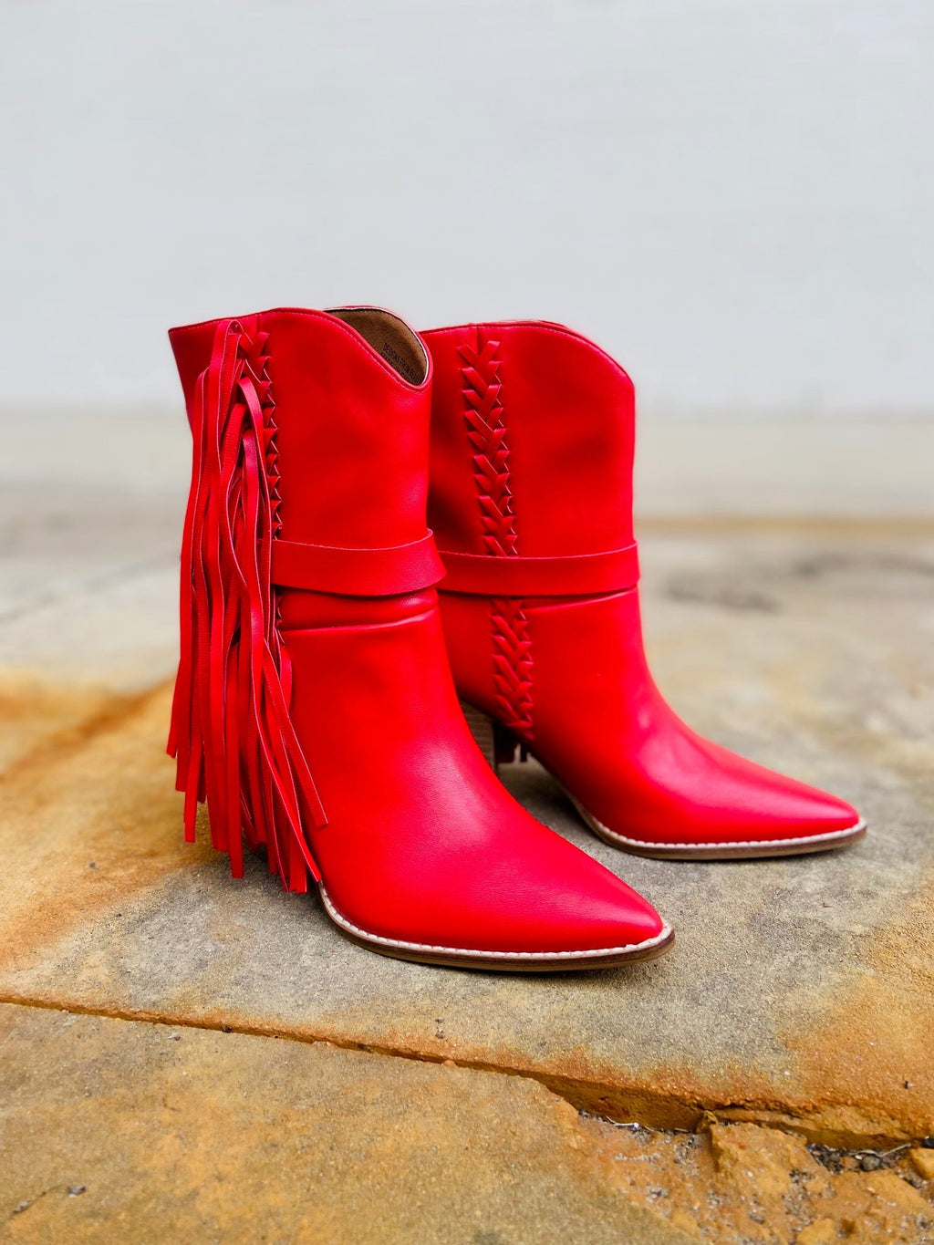 Slip into something a little saucy with these Lady in Red Boots! The ultra-casual fringe-covered booties have a classic western style with a flirty pointed toe, red leather whipstitching and a sassy 3" wood heel, for a look that stands 10" tall. Show 'em who's boss with a splash of daring red!