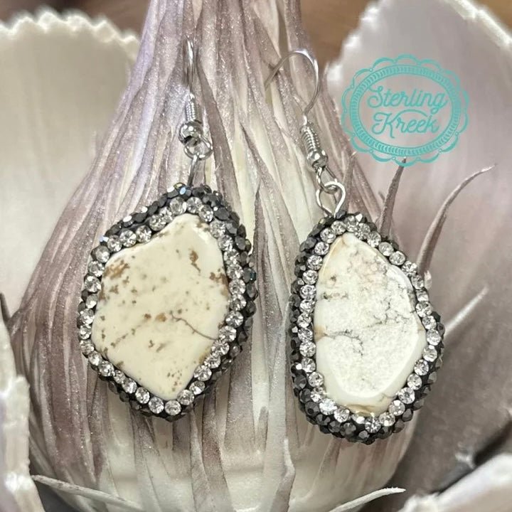 These earrings are a pleaser! Each white rock is surrounded with rhinestones. These are lightweight. Although each earring are similar in size they do vary a little.   LENGTH: 1.25"  0.6 OZ