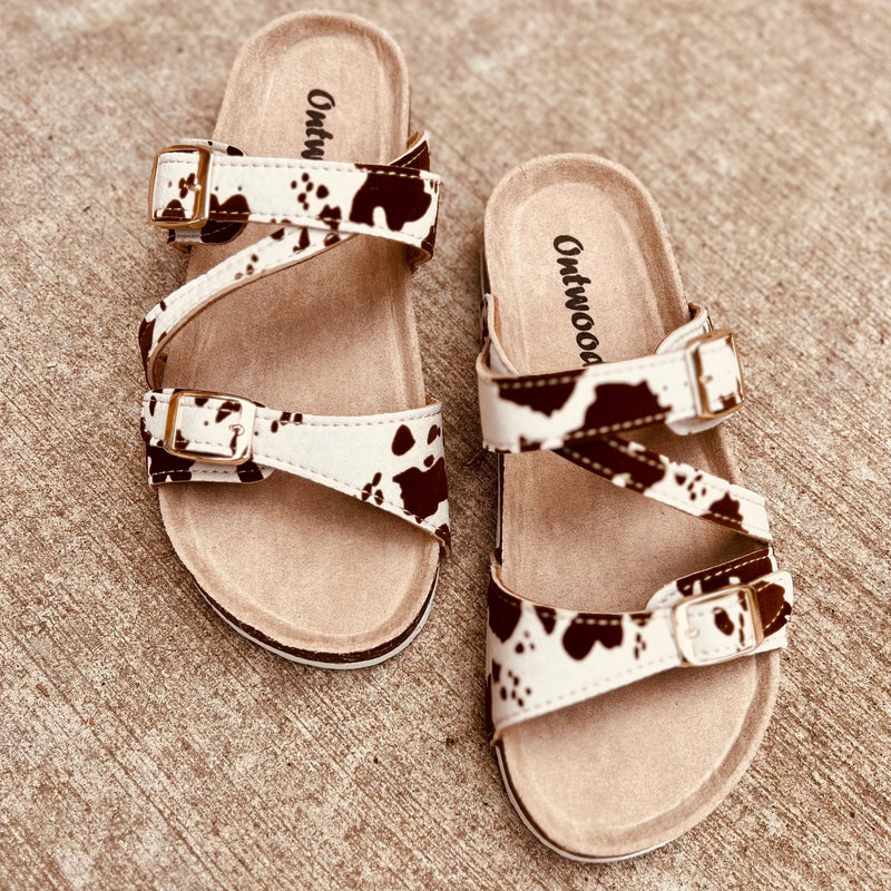 Complete your look in style with these beige combo sandals. Crafted with a brown and white cow print, they feature a strappy design, slides, and a comfort sole for a comfortable fit. Perfect for everyday wear.