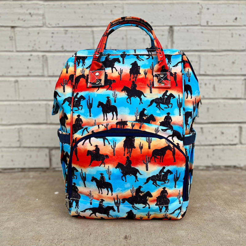 This Desert Cowboy Diaper Bag is perfect for those little cowpokes who like to roam! It's made of easy-to-clean nylon, so you don't have to worry about a wild ride ruining its good looks. Yee-haw!