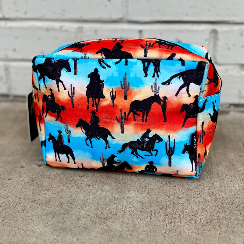 Be a true outlaw with the Desert Cowboy Cosmetic Case! This western-inspired design features a cowboy taking a break in a desert scene, making it the perfect accessory for anyone who wants to express their wild side. So stow your cosmetics in style and join the cowboys of the wild west!  featuring top zipper closure. Navy detailing.  Matching diaper, duffel, tote, and cosmetic bags sold separately.   10"L x 7"H