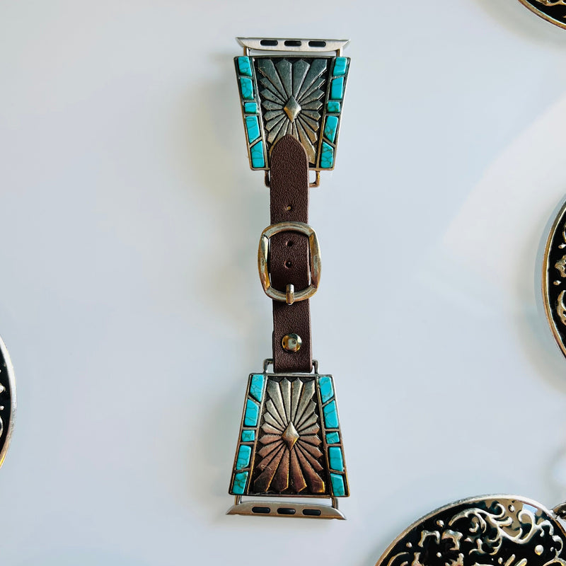This Montezuma Miners Leather Watch Band features a sleek design with a brown leather material and silver concho with turquoise stones. It is designed to fit 38-40MM & 42-44MM watch faces. Upgrade your look with this stylish band.