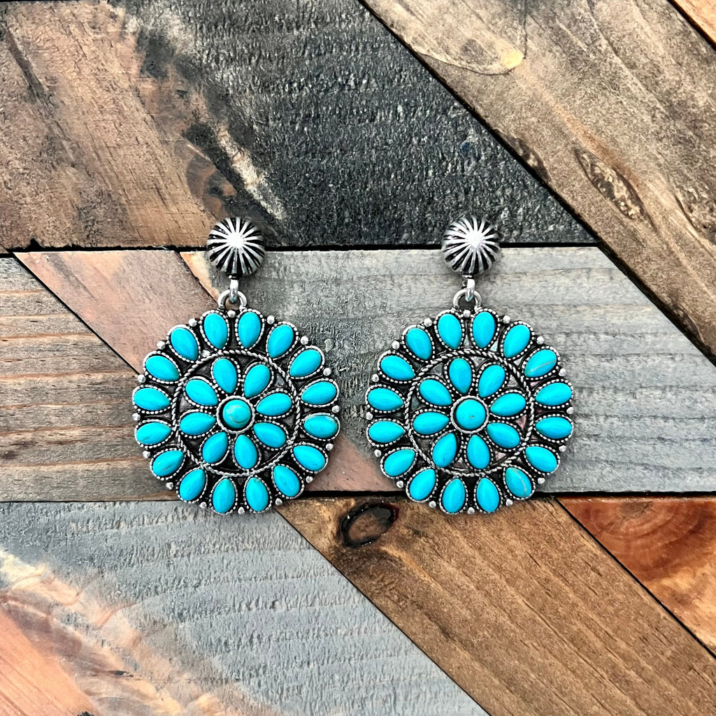 These As The World Turns Earrings will have you rockin' and rollin' in western concho style! From the high polish silver to the turquoise stone, these dangles will be sure to turn some heads. Take your style for a twirl! (Yeehaw!)