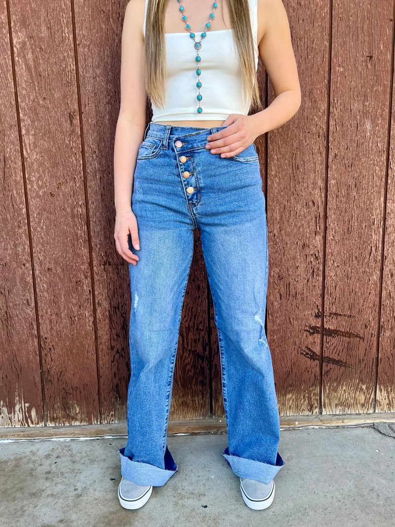 Criss cross waist jeans. Distressed Wide leg jeans. High waisted jeans. Button up straight leg jeans. High waisted medium wash jeans. Medium wash wide leg jeans. Women's western boutique. Women's western wear. Women's western fashion. Small business. Woman owned. Trending fashion.