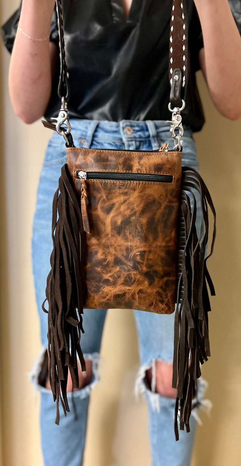 Leather bag. Leather strap. Tooled leather. Buckstitch. Rawhide bag. Leather fringe. Leather bag with fringe. Brown leather bag. Tooled leather strap. Women's bag. Western style bag. Cowgirl style bag. Women's western accessories. Women's western boutique. Western boutique. Women's boutique. Small business. Woman owned. 