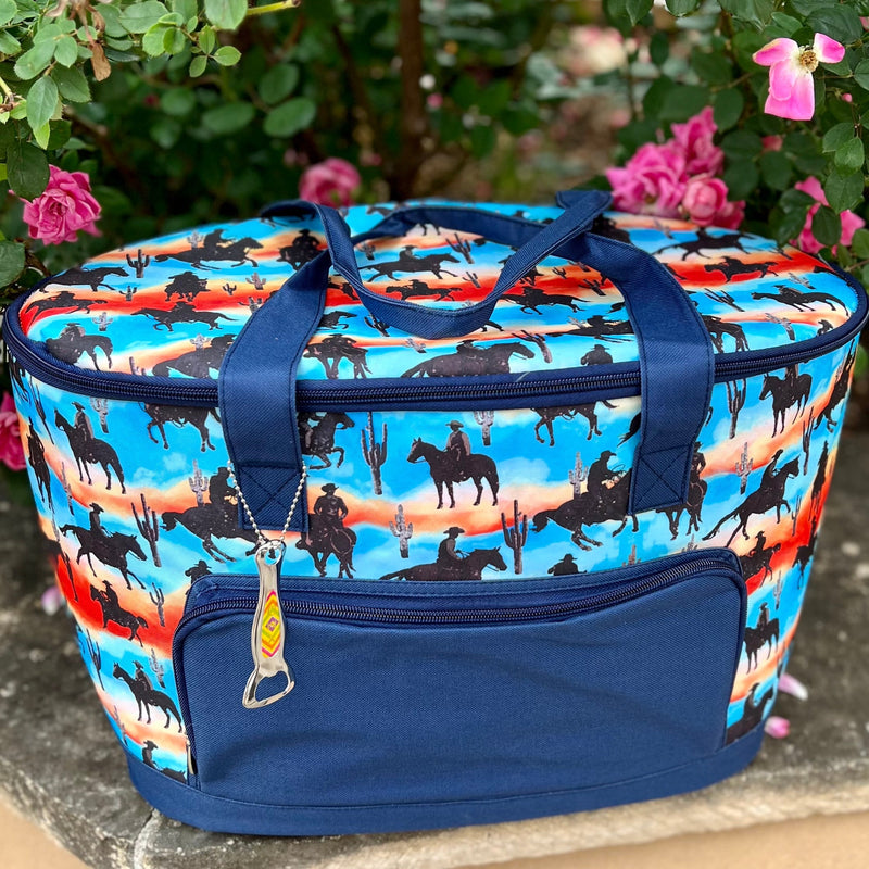 The Desert Cowboy Cooler Bag is sure to impress, with its multi colored design, desert horseback scent, cacti, and insulated inside compartment. Store all your essentials in one stylish and convenient cooler bag. Also comes with a handy dandy bottle opener. Perfect for any adventure.  24" L X 14"H  Matching pieces sold separately.