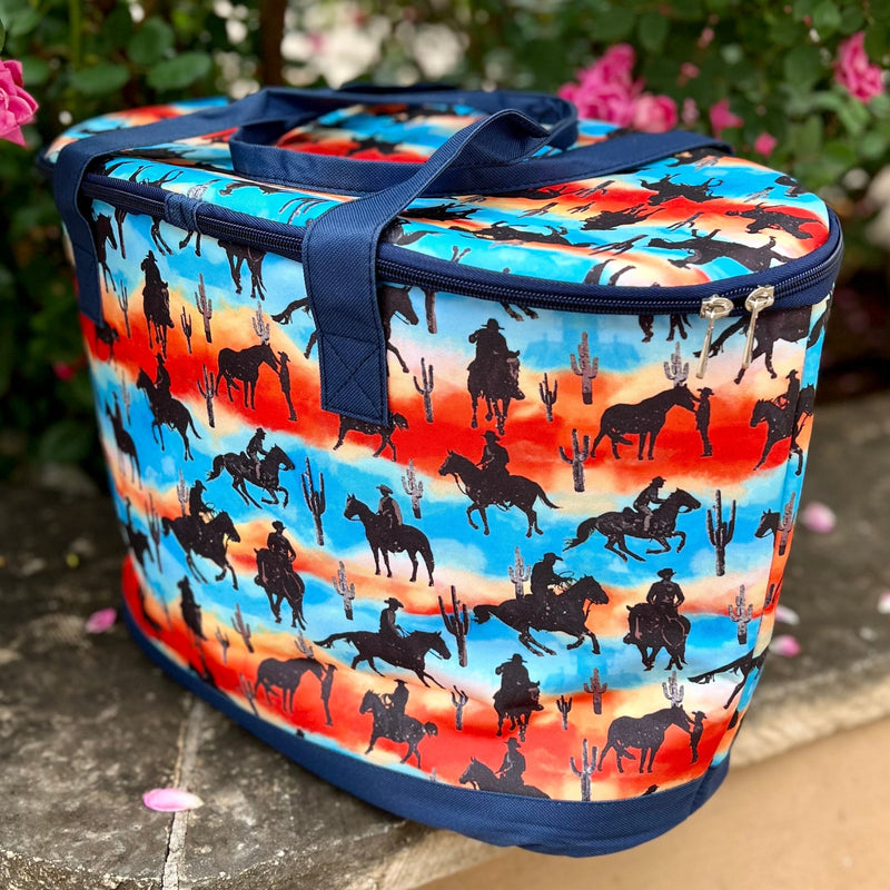 The Desert Cowboy Cooler Bag is sure to impress, with its multi colored design, desert horseback scent, cacti, and insulated inside compartment. Store all your essentials in one stylish and convenient cooler bag. Also comes with a handy dandy bottle opener. Perfect for any adventure.  24" L X 14"H  Matching pieces sold separately.